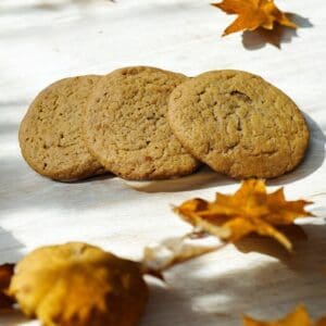 Cookies with autumn leaves on white surface.