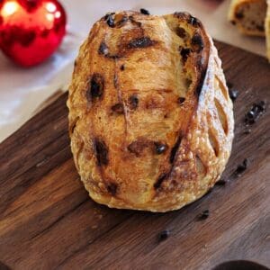 Bread loaf on wooden board, red hearts.