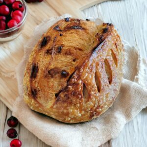 Cranberry sourdough bread on wooden table.