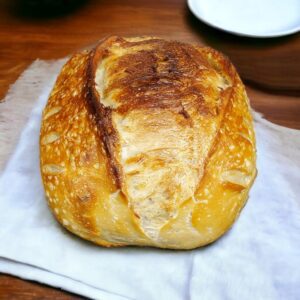 Crusty sourdough bread on wooden table.