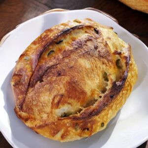 Round loaf of bread on white plate.