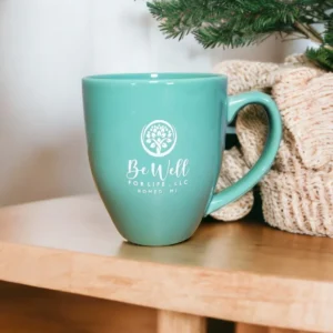 Green mug on table with holiday decor.