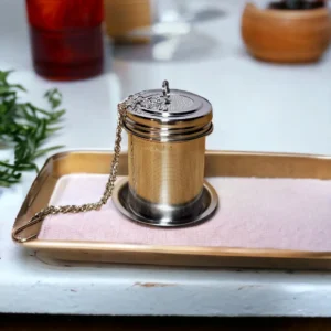 Metal tea infuser on rectangular tray.