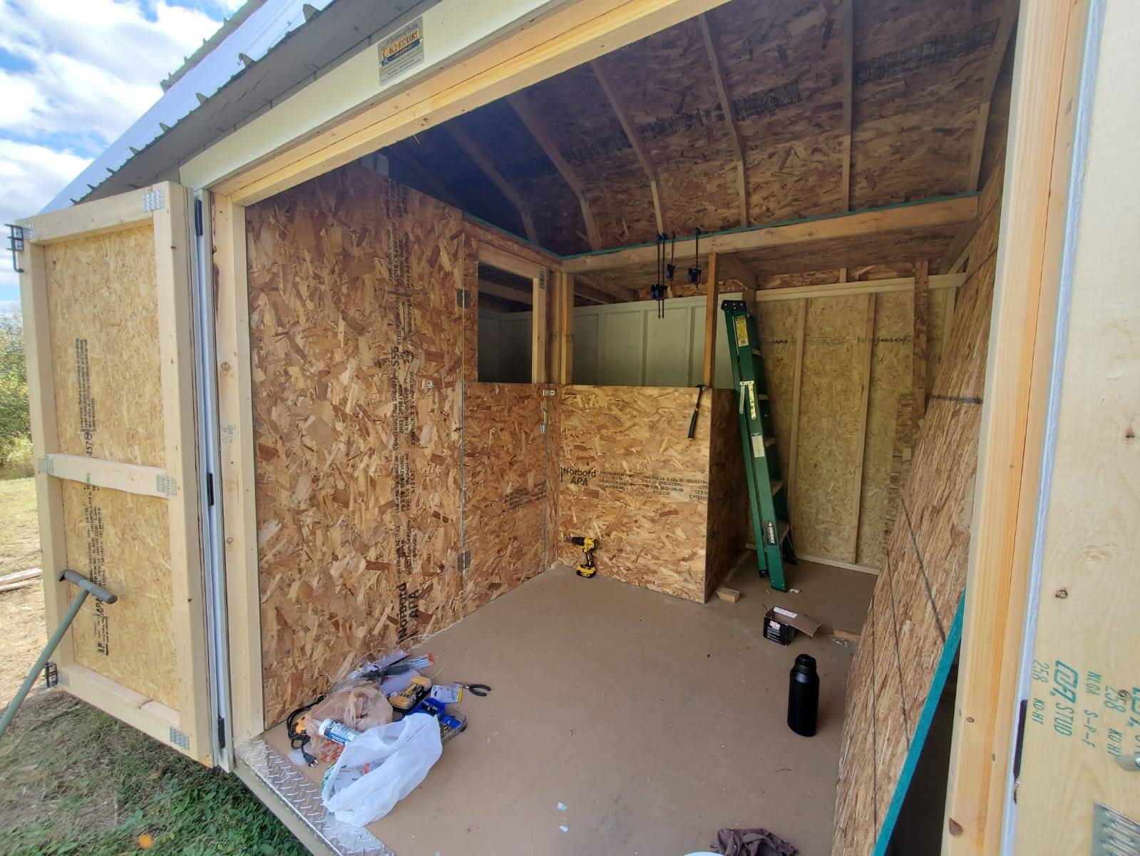 Wooden shed interior with construction materials inside.