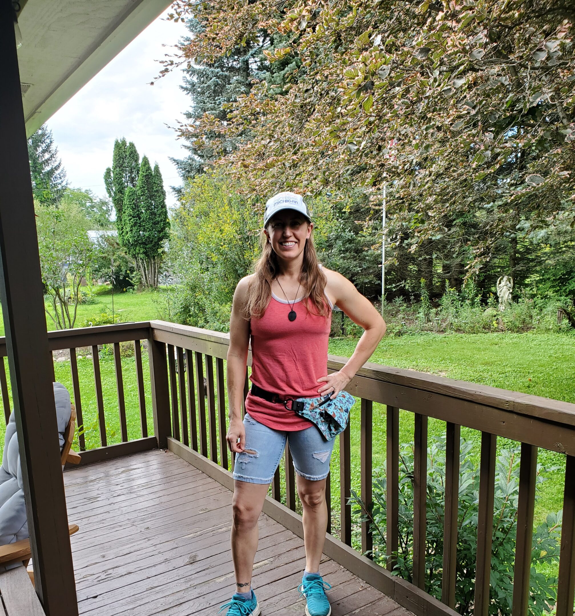 Woman standing on porch in casual attire.