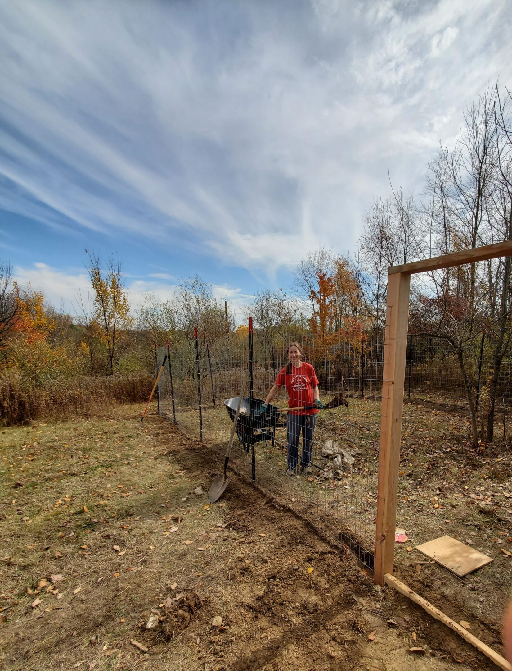 Person working on a fence in garden.