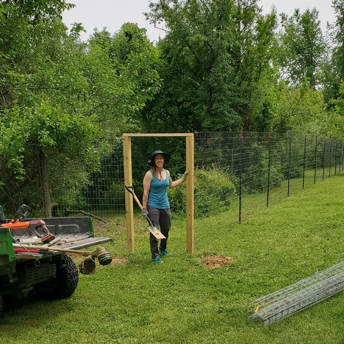 Person building a fence in a garden.