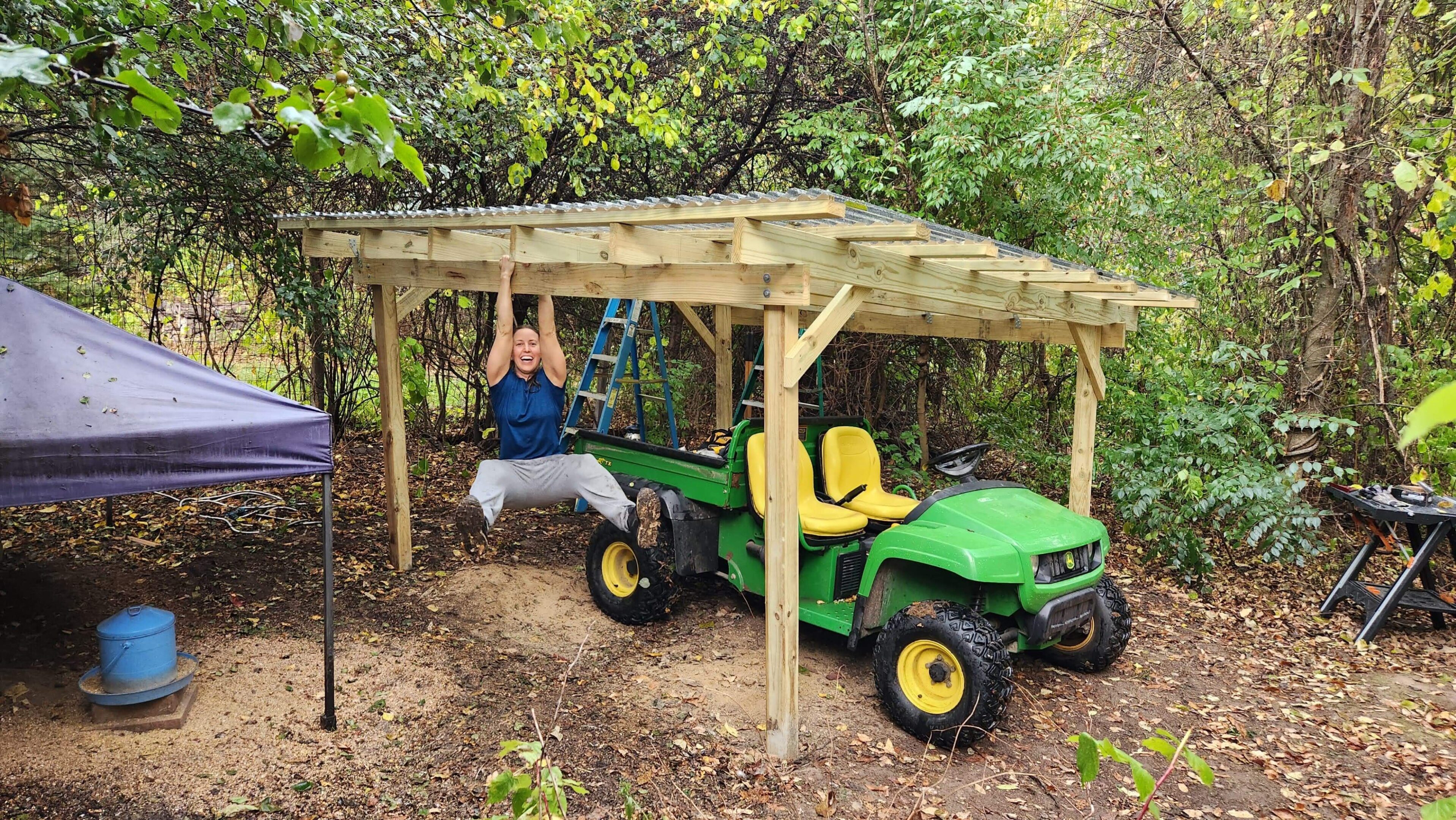 Person hanging from wooden structure over tractor.