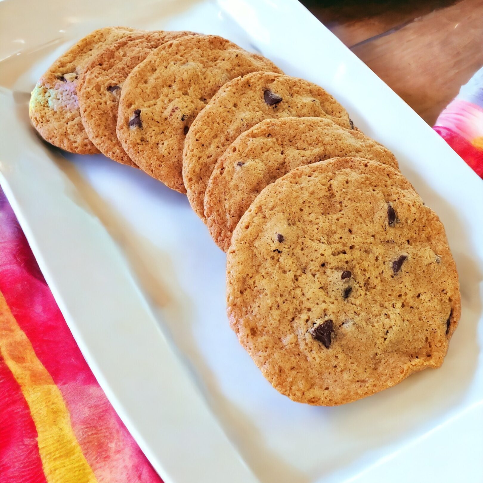 Chocolate chip cookies on a white plate.